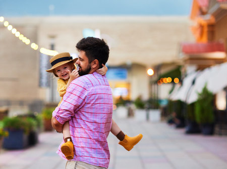 excited baby daughter having fun with daddy on the streetの写真素材