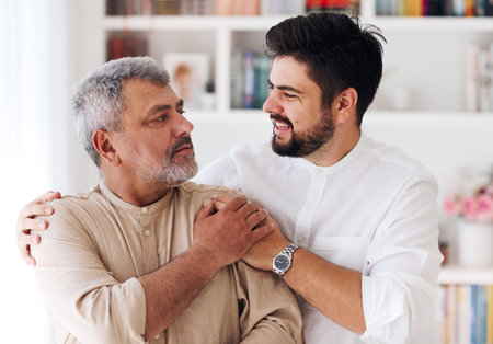 portrait of cheerful adult father and son at homeの写真素材
