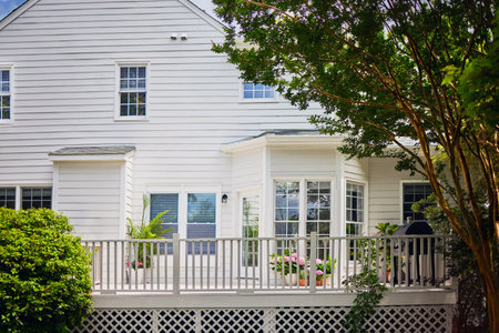 White wooden house with white picket fence and flowers on the balconyの写真素材