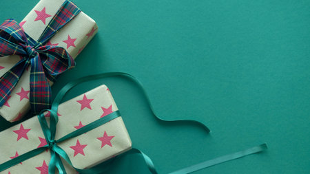 Christmas gift box wrapped in ornament paper on green background . Top view.