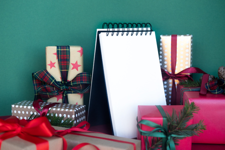 Notebook with new years goals. Christmas composition of various gift boxes wrapped in different paper. Top view. Copy space.の写真素材