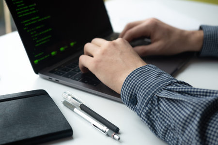 Man working on his computer. Man's hands with laptop.