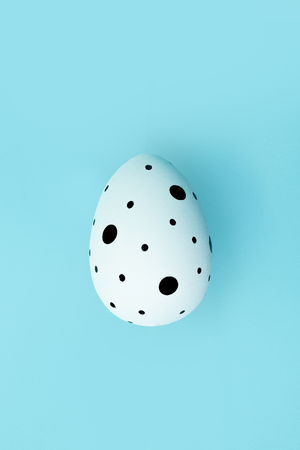 One Easter egg on blue background. Easter concept. Copy spaceの写真素材