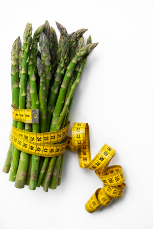 Delicious asparagus and measuring tape isolated on whiteの写真素材