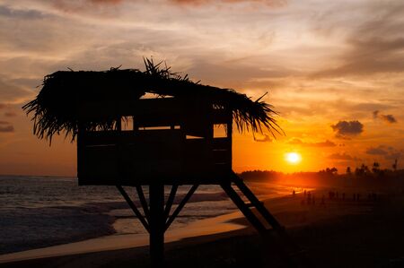 observation post of the rescuer on the ocean coast in Koggala, Sri Lanka, boulders in the Indian ocean at the sunsetの写真素材
