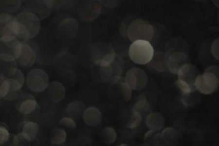 Silvery boke on a black background. brilliant vintage lights background. de-focused