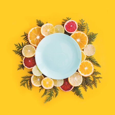Juicy flat lay with slices of orange, lemon, lime and herbs. Happy yellow summer background, citruses, vitamins concept. Top view, place for text, template for banner, poster.の写真素材
