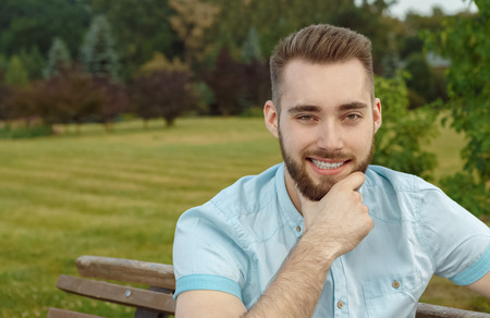Young man posing on park benchの写真素材