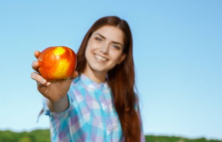 Beautiful girl with apple in the parkの写真素材