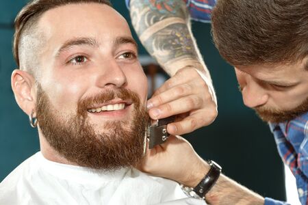 The portrait of a smiling hipster during the shaveの写真素材