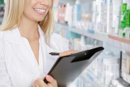 Beautiful pharmacist accounting the product in drugstoreの写真素材