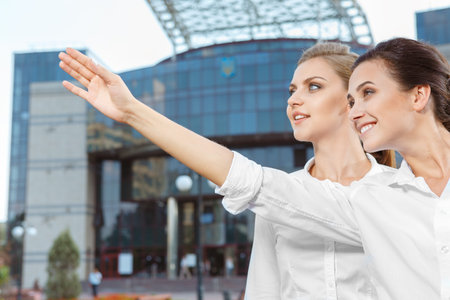 Two beautiful businesswoman next to office buildingの写真素材
