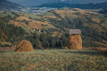 Two hay ricks in the countryside with mountains in backgroundの写真素材