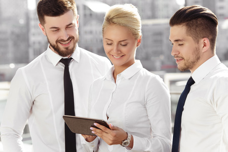Young businesswoman showing her partners something on a digital tabletの写真素材