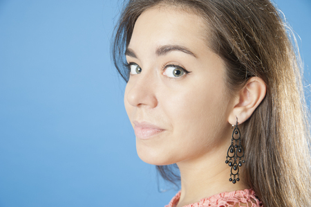 Portrait of a young pretty girl close-up.
Studio photography on a blue background. Age 18 years old girl.の写真素材