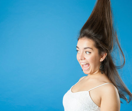 Girl with a raised hair screams.Studio photography on a light blue background.の写真素材