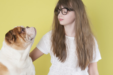 The girl and an English bulldog.
Studio shot on a green background.の写真素材