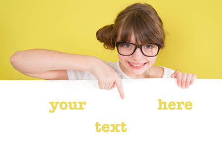 Girl holding a white sheet with space for text.
Studio shot on a green background.の写真素材