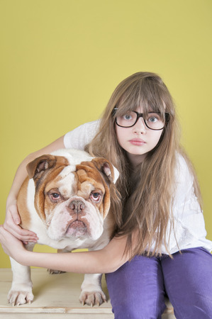 The girl and an English bulldog.
Studio shot on a green background.の写真素材