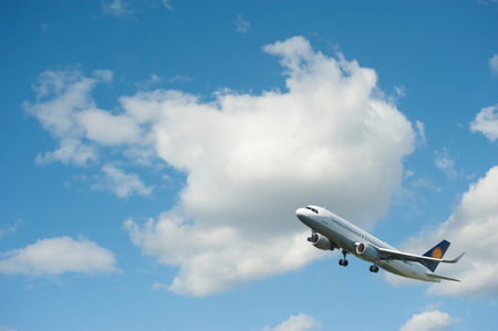 Plane takes off against the blue cloudy sky.Takeoff. Collage.のeditorial素材