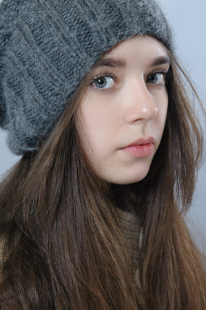 Portrait of a beautiful girl in a warm knitted hat.
