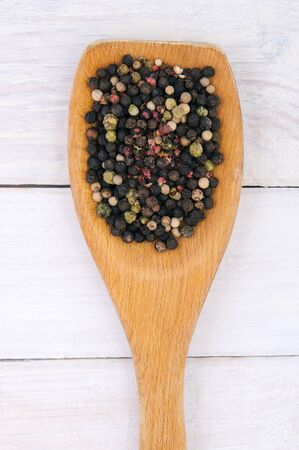 Assorted Dried spicy pepper in a wooden spoon on the table. Professional studio photography.の写真素材