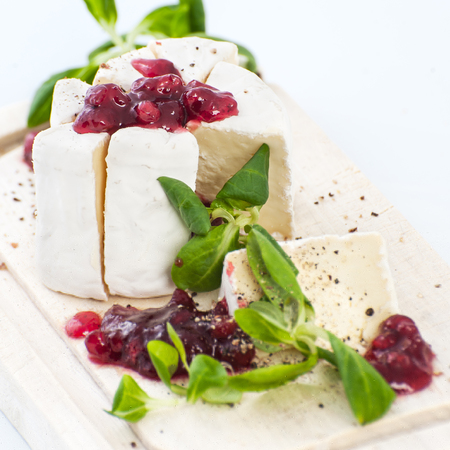 Cheese Brie with cowberry sauce and fresh lettuce leaves.の写真素材