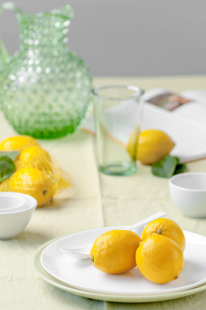 Ripe lemons on a plate on a table covered with a light green tablecloth.
の写真素材