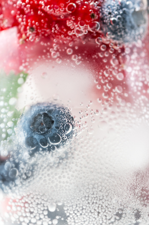 Fresh blueberries and red currants in cold gassed water. Macro shooting - background image.の写真素材
