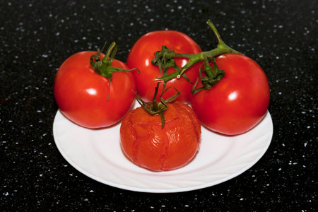 roasted tomato with fresh tomatoes on the plateの写真素材