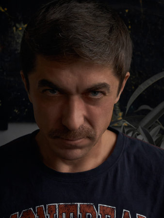 Intense Gaze of a Man with a Mustache and Blue Eyes