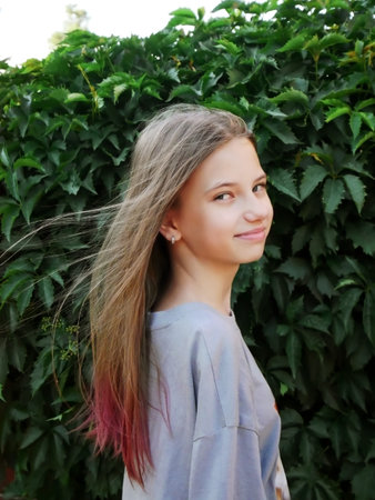 teen girl on the green leaves greenery