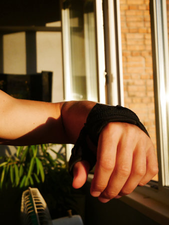 A hand with a bandage on the wrist, showing healing wounds near the windowsの写真素材