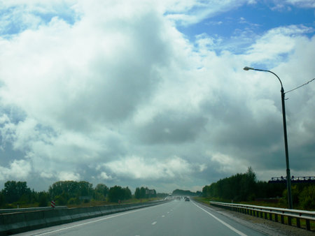 Wet Road Under Dramatic Cloudy Skyの写真素材