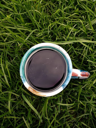 Top-Down View: Artistic Mug Rests on Vibrant Green Grass