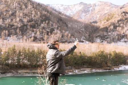 Selfie of man by beautiful turquoise mountain lakeの写真素材
