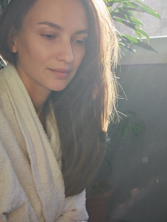 Woman in Robe Bathed in Golden Sunlight, Morning Serenity