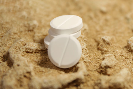 White Medicine Pills on Earthy Textured Stone Backgroundの写真素材