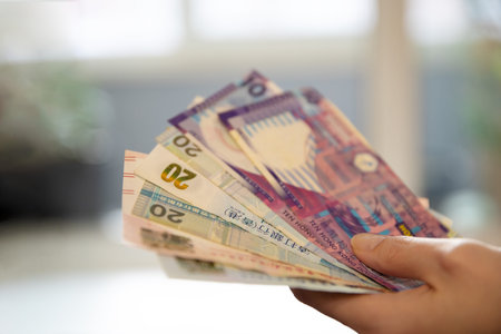 Woman holding a fan of Hong Kong dollar banknotes. Concepts of finance, currency exchange, economy,...