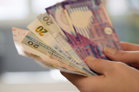 Woman holding a fan of Hong Kong twenty dollar banknotes. Currency and finance concept for banking, economy, and investment.の写真素材