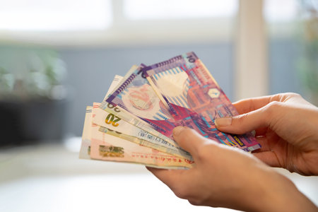 Woman holding Hong Kong dollar banknotes, counting money. Financial transaction and personal finance management concept. Currency exchange.の写真素材