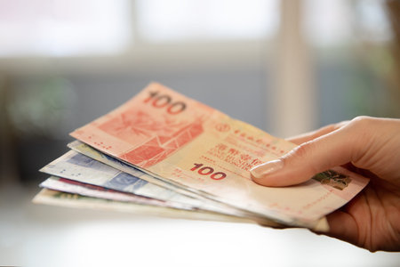 Woman holding Hong Kong dollar banknotes. Asian currency for payment, financial transaction, business, banking concept.の写真素材