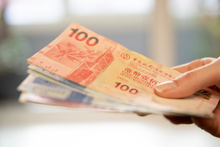 Woman holding a stack of Hong Kong dollar banknotes. Concept of finance, payment, currency, business transaction, and purchasing power.の写真素材