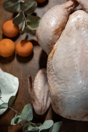Raw chicken or turkey on a cutting board, ready for cooking. Holiday meal preparation, cooking concept for Thanksgiving or Christmas.の写真素材