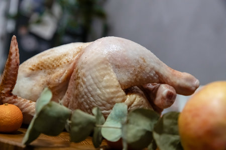 Whole turkey ready for cooking on a wooden table. Uncooked poultry for a festive meal. Holiday food preparation for Thanksgiving or Christmas.の写真素材