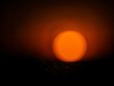 Blurry big orange circle with dark space. Abstract glow effect for creative design. Bokeh texture background.の写真素材