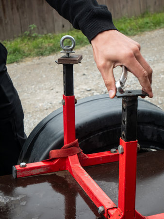Man using wrench to adjust bolt on metal trailer stand. Handyman repairing metal frame. Maintenance...