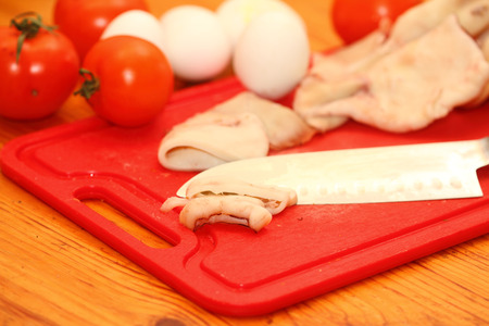 slices of boiled squids and other inrgediyenta on a red boardの写真素材