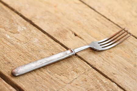 background a metal old fork on an old boardの写真素材