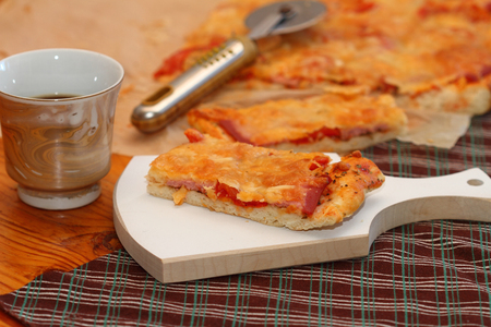piece of pizza with sausage, tomatoes and three types of cheeseの写真素材